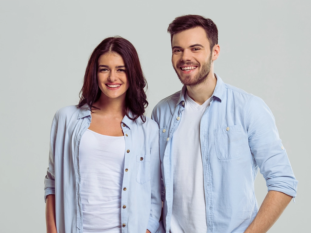 young stylish couple in blue outfits smiling